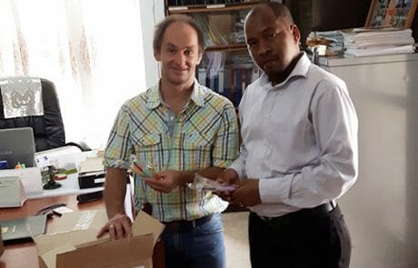Handover of several hundred children's toothbrushes to Dr. Samosa Tarimo (AgRMO) in his office